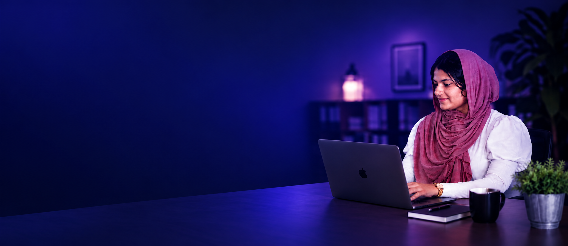 Hashim Nasreen working at a laptop against a blue background